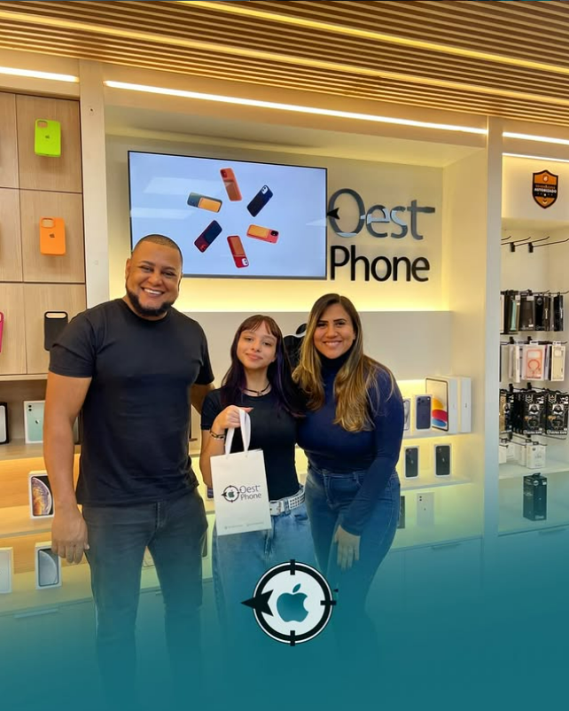 Cliente na loja física OestPhone, em frente ao letreiro da marca